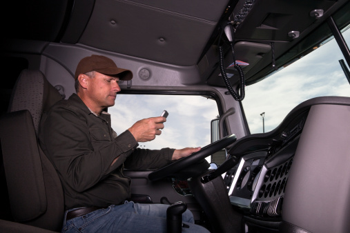 A truck driver texts while behind the wheel